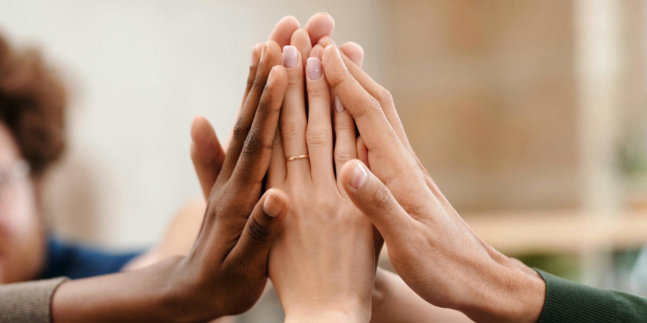 Close-up of diverse group hands high-fiving symbolizing teamwork and unity.